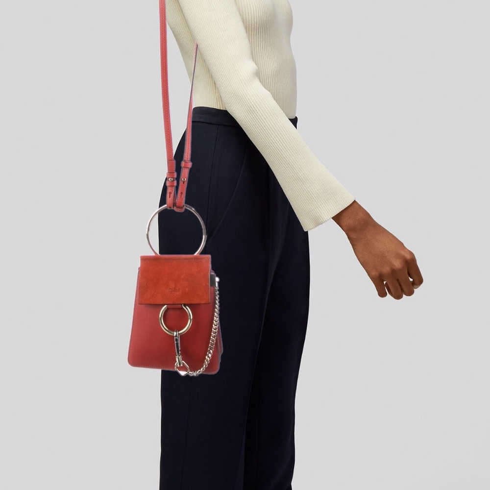 Orange Chloé leather bucket bag with gold hardware and suede trim.